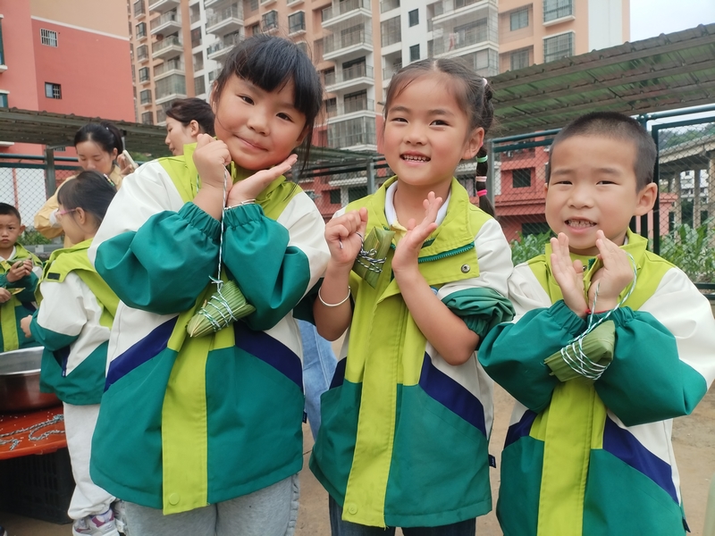 小朋友開心展示包好的粽子。