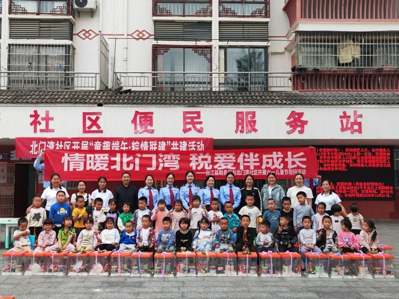 稅務(wù)干部與孩子們合影留念。