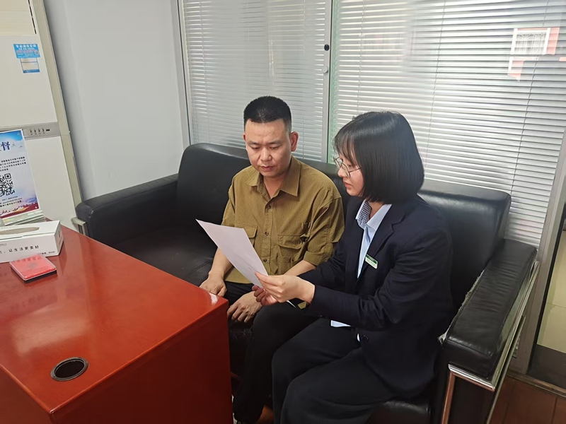 郵儲銀行工作人員給客戶介紹金融產(chǎn)品及服務(wù)。