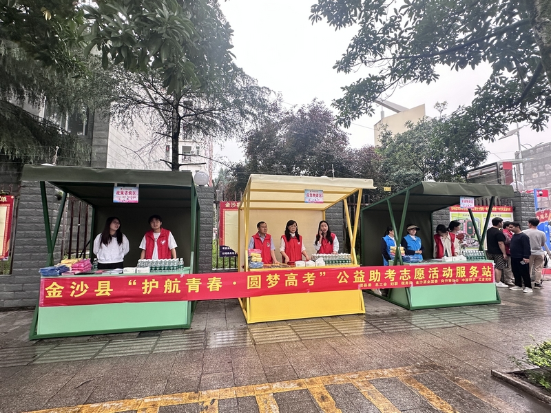 nEO_IMG_為做好社會保障工作,國家稅務總局金沙縣稅務局與團縣委、總工會、婦聯等部門聯合開展公益助考志愿服務活動,在考點外設置志愿活動服務站,為考生發放雨衣、礦泉水等物資。敖歡攝