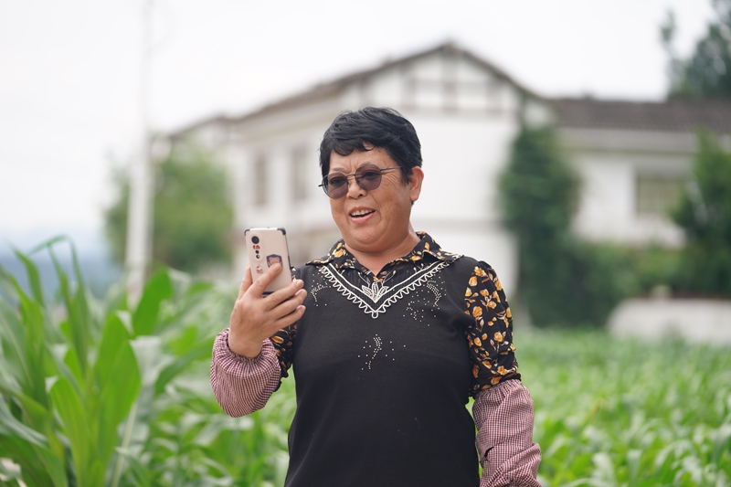 淹壩村村民鐘德容正與遠在浙江務工的兒子通視頻。吳艷禹攝