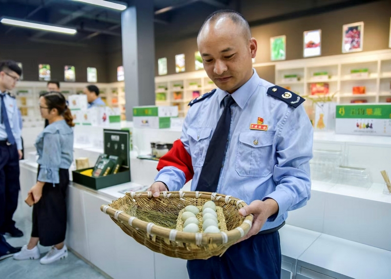 圖為國家稅務總局畢節高新區稅務分局派駐赫章雙坪鄉的第一書記周榮正為村民售賣雞蛋。村委會供圖