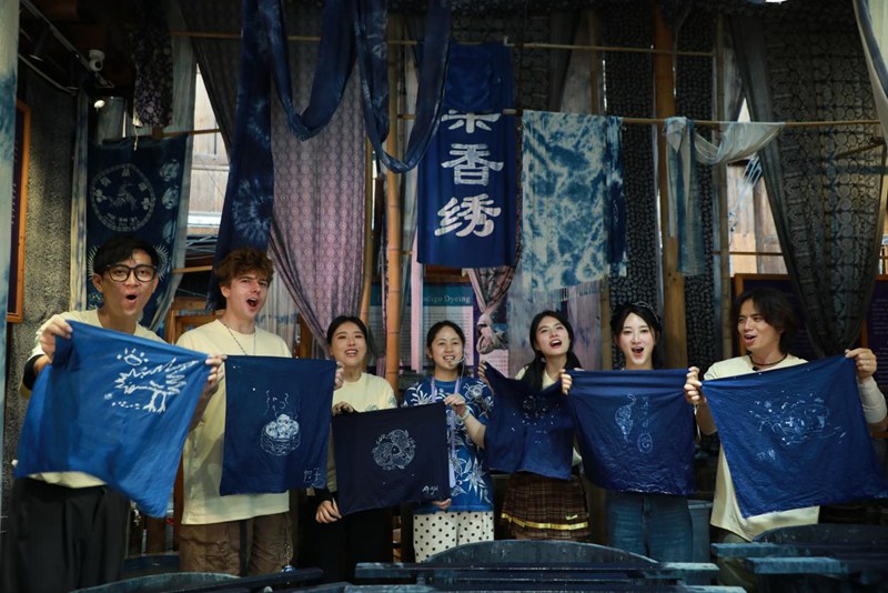 嘉賓們跟著村民陸玉梅學習蠟染。