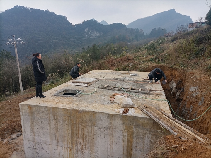 工作人員現場測量蓄水池尺寸。