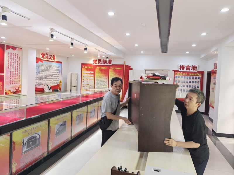 退休干部石碧玉同志(左一)與干部職工共同轉(zhuǎn)移單位底樓物資。