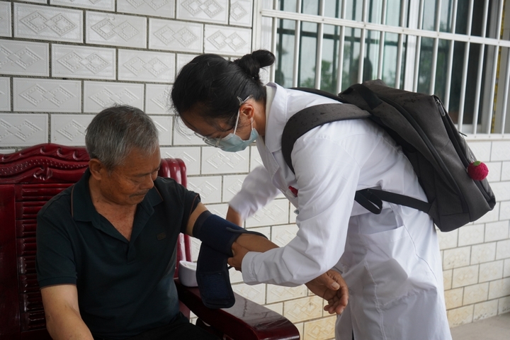 村醫正在給老人量血壓。黃源匯 攝.jpg