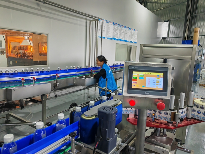 生產(chǎn)車間內(nèi)，工人們有條不紊地進(jìn)行著灌裝、貼標(biāo)、包裝等工序。陳昱 攝.jpg