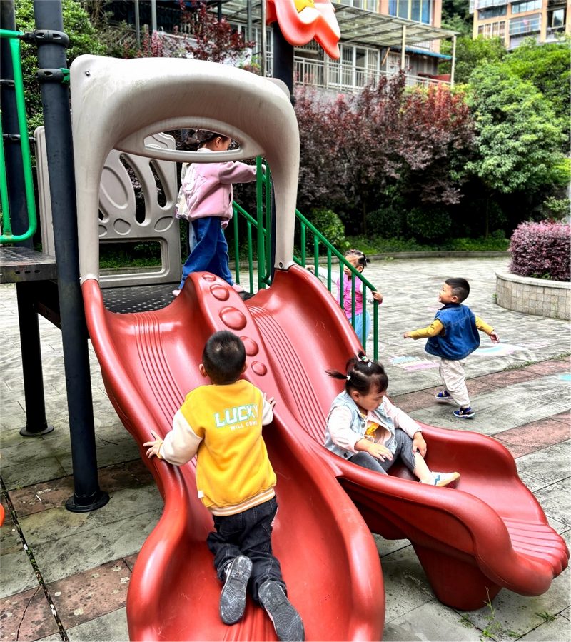 兒童樂園里，滑梯笑聲和樹蔭里的閑談聲纏在一起。王燁攝