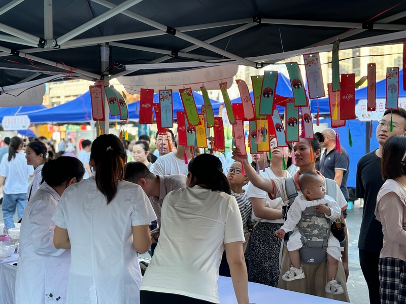 本草燈謎墻前市民猜謎互動。王燁攝