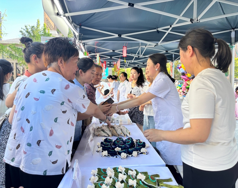 市民在攤位前領取中藥香囊。王燁攝