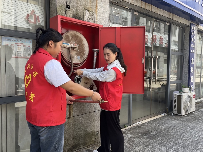 手把手教居民使用滅火器。
