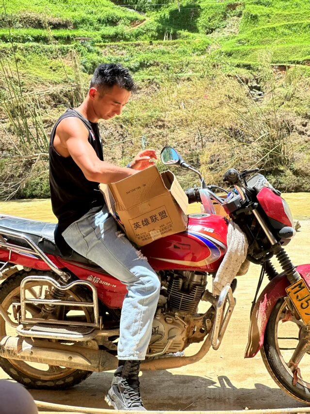 平永橋騎著摩托車運送救災物資。