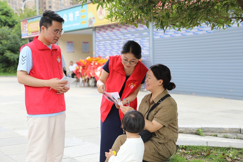 南山社區(qū)網(wǎng)格員正在給市民宣傳有關(guān)政策。
