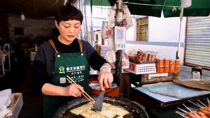 羅明菊在自家的攤位煎制六廣臭豆腐進行售賣。