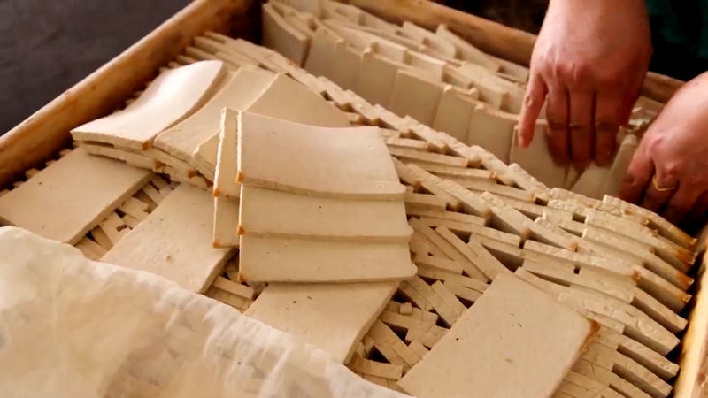 制作好的豆腐切成小片放入木框進行天然發酵。