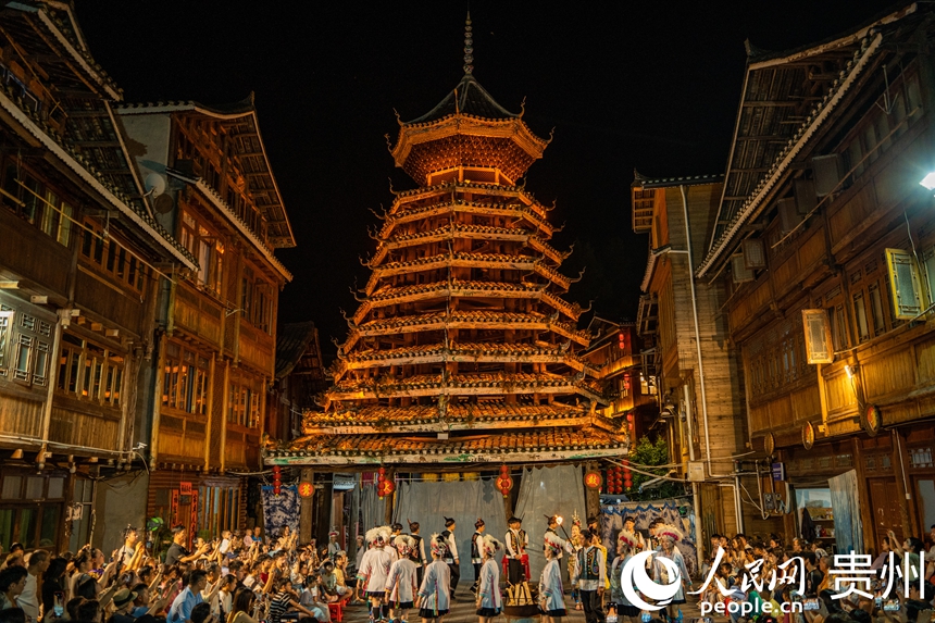 夜幕降臨，村民在鼓樓前為游客帶去民俗表演。人民網 陽茜攝