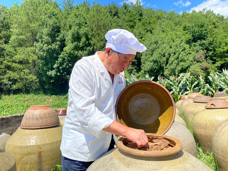 溫邦賢正在仔細(xì)查看醋醅成色。