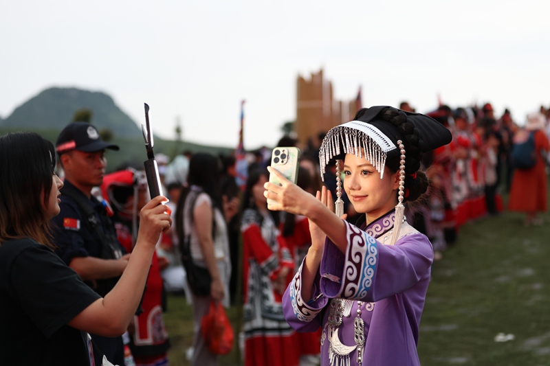 游客在貴州省畢節市赫章縣彝族火把節開幕式現場進行直播。