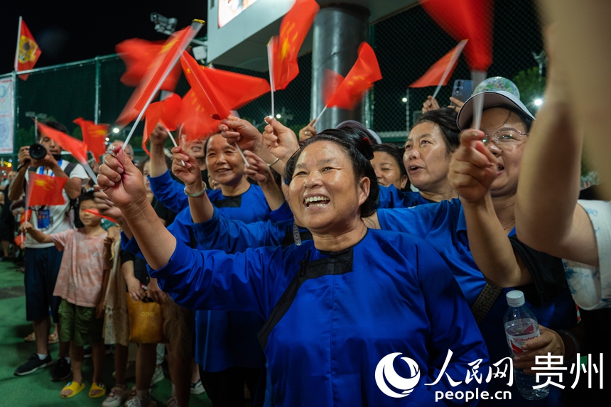 觀眾揮舞著紅旗為巡游隊伍喝彩。人民網 陽茜攝