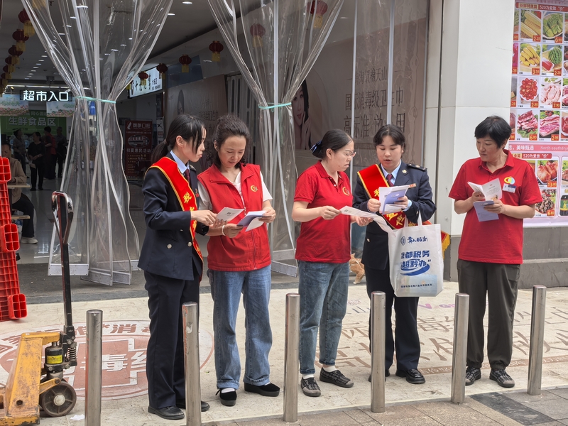 “枝己”志愿服務隊向超市員工講解稅費政策。胡凡銳攝