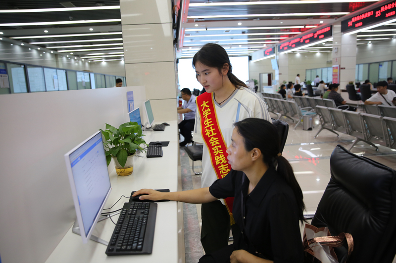 大學生志愿者在自助辦稅區輔導納稅人辦理涉稅業務。鄭婷攝