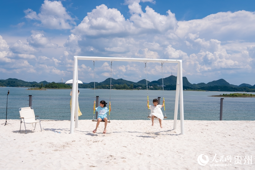 小朋友在湖邊露營基地的沙灘上嬉戲。人民網記者 涂敏攝