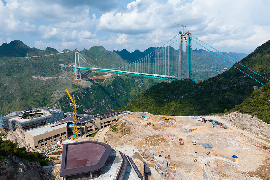建設中的云渡服務區與遠處的大橋同框。人民網記者 涂敏攝