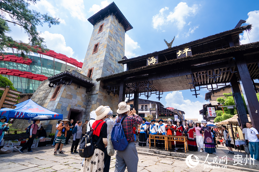 游客參觀體驗(yàn)度假區(qū)內(nèi)的彝族攔門(mén)酒。人民網(wǎng)記者 涂敏攝