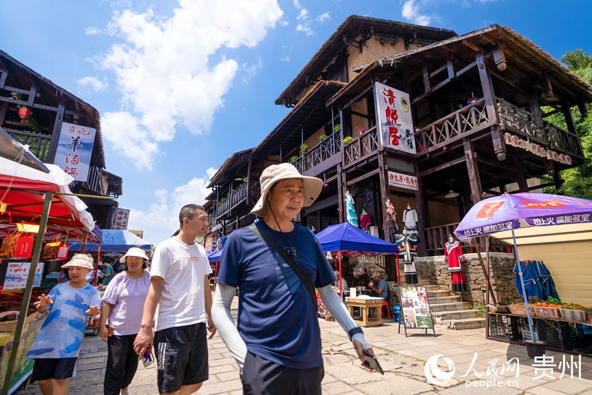 游客在景區(qū)內(nèi)的海坪彝族特色旅游度假小鎮(zhèn)參觀游覽。人民網(wǎng)記者 涂敏攝