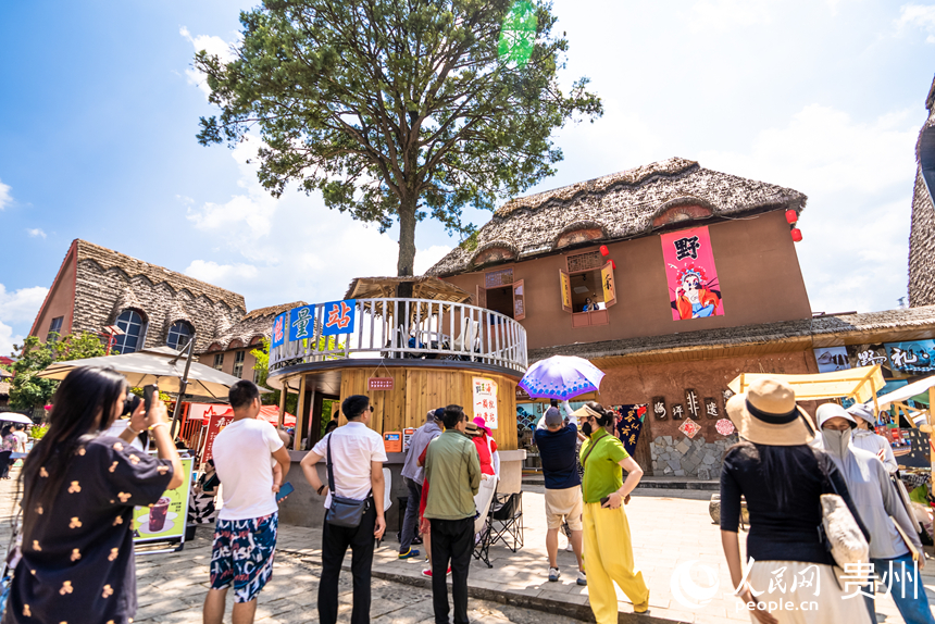 游客在景區(qū)內(nèi)的海坪彝族特色旅游度假小鎮(zhèn)觀看表演。人民網(wǎng)記者 涂敏攝