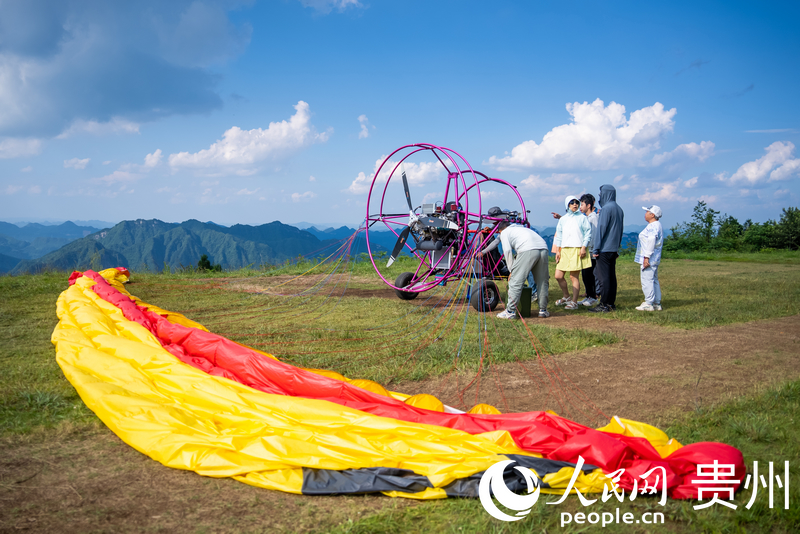 游客體驗動力滑翔傘飛行。人民網記者 涂敏攝