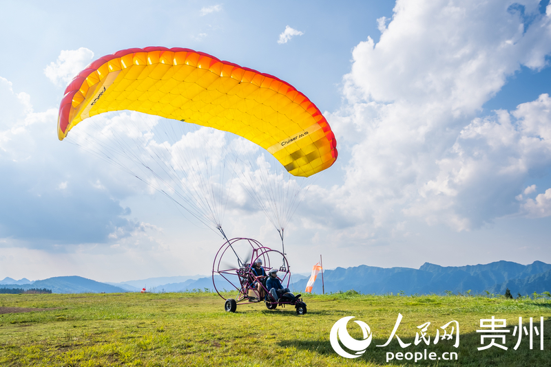 游客體驗動力滑翔傘飛行。人民網記者 涂敏攝