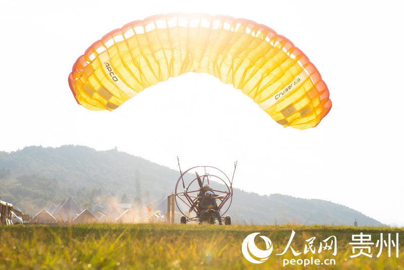 游客體驗動力滑翔傘飛行。人民網記者 涂敏攝