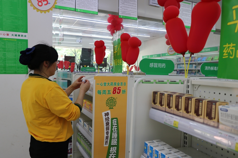 店員正在整理平價(jià)藥柜藥品。