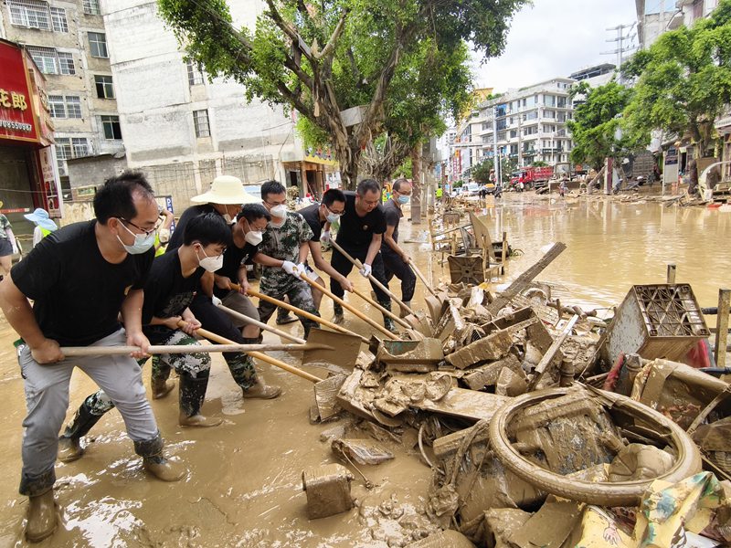榕江縣稅務干部清理網格責任區內淤泥。