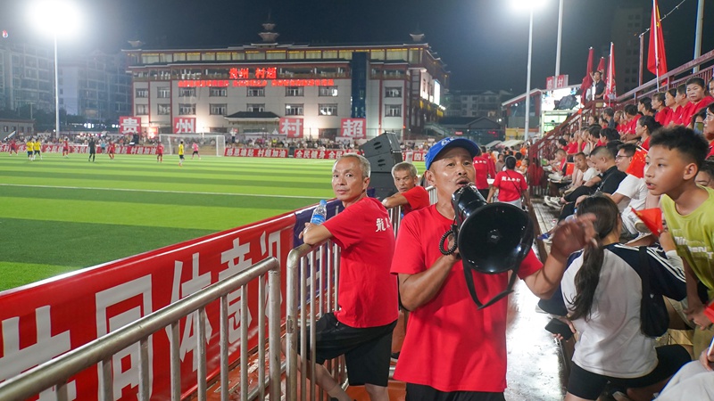楊明剛在球場邊組織啦啦隊為球隊加油助威。