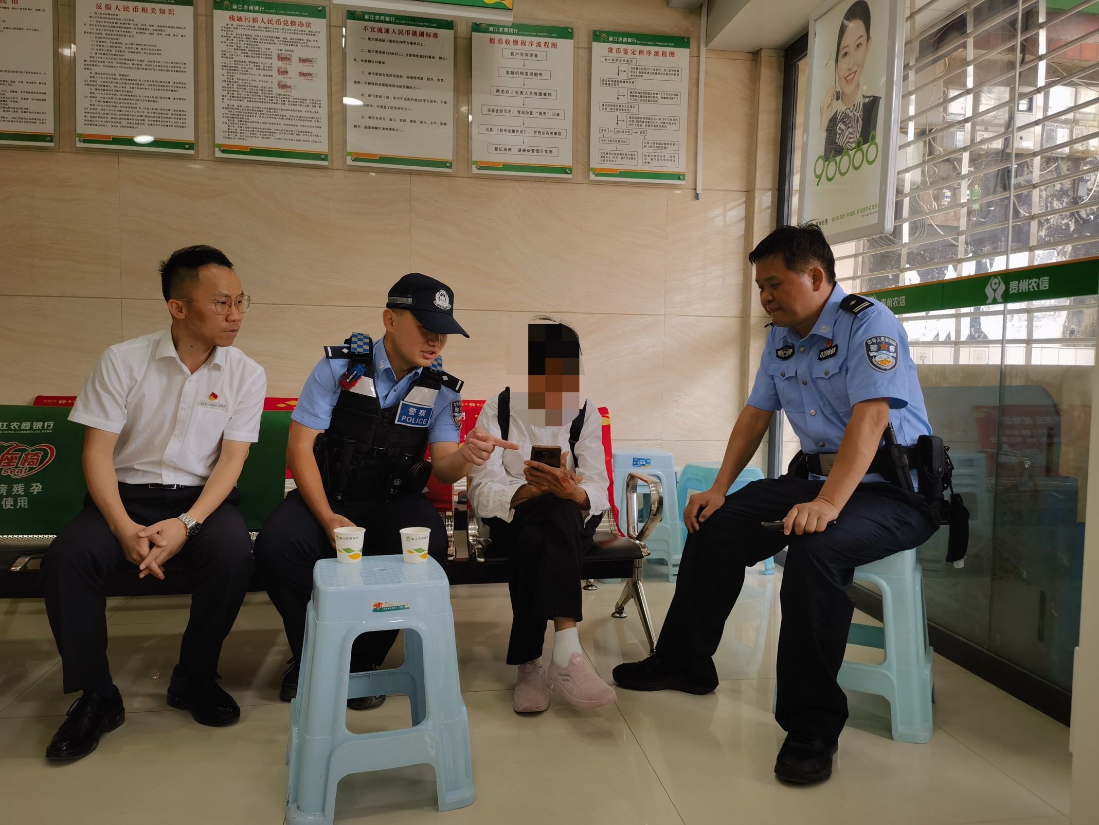 民警及銀行工作人員對(duì)劉奶奶進(jìn)行勸阻。麻江農(nóng)商銀行給供圖