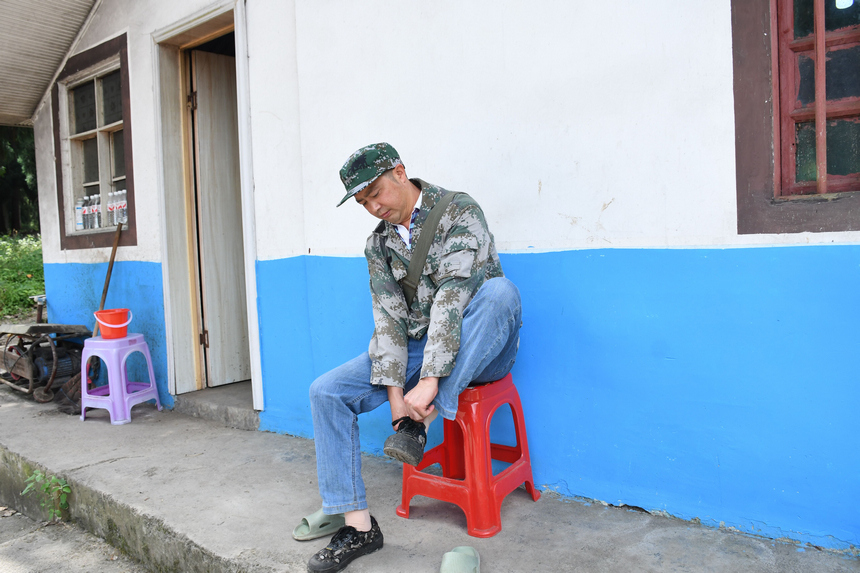 姚克禮換上膠鞋準備巡林。