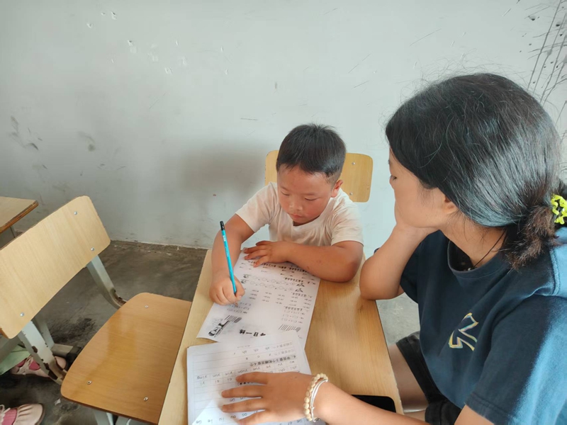 志愿者為學(xué)生指導(dǎo)課業(yè)。