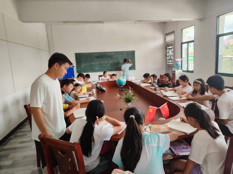 志愿者為學(xué)生指導(dǎo)課業(yè)。