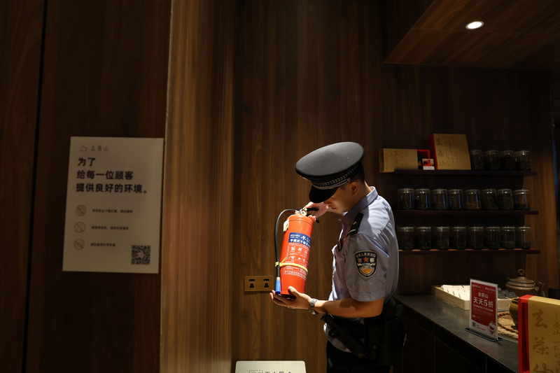 南明公安分局民警在商戶店內(nèi)檢查消防。