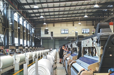 畢節宏盛紡織科技有限公司廠房內，200余臺噴水織機正高速運轉。廖婉君攝