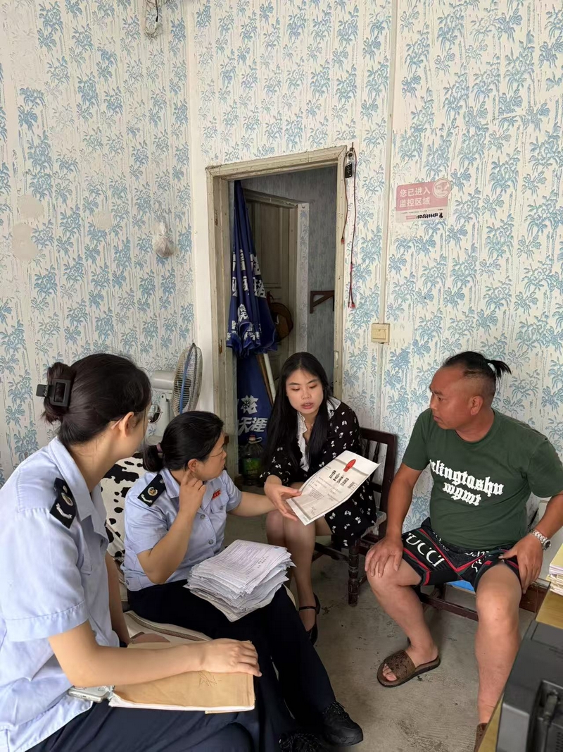 稅務人員走訪個體工商戶,了解其經營情況并開展稅務輔導.