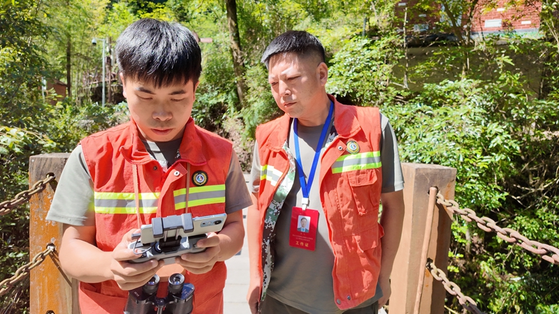 吳攀勝(左)認真的操作無人機。稅會靜攝