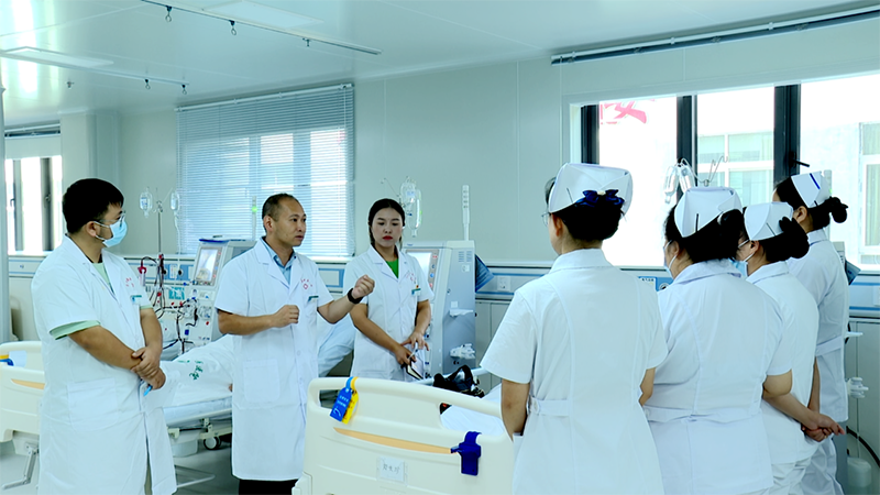 病房內，來自廣州市中西醫結合醫院的伍浩文醫生正帶領團隊查看病人情況，同時以這樣的實踐教學方式，向普定縣中醫醫院的醫護人員傳授專業知識，助力他們穩步成長。