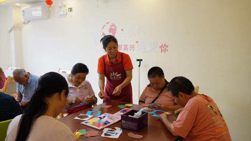 貴定縣老年養護樓護理組長黃中麗與老人一起開展益智類活動。