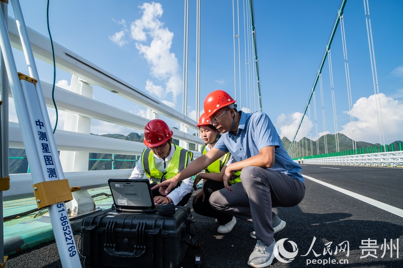 馬宗源在大橋上教學(xué)生如何使用測(cè)量工具。人民網(wǎng) 陽茜攝.jpg