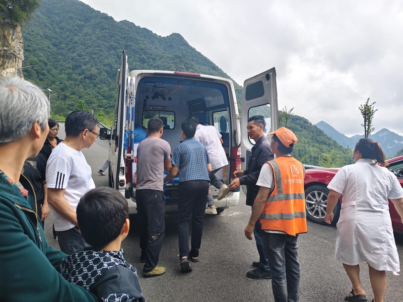 眾人合力將傷者抬上救護車送醫。習水縣融媒體中心供圖.jpg