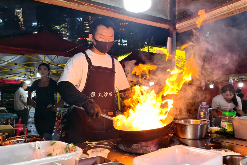 火把節(jié)系列活動(dòng)期間，威寧城區(qū)會(huì)展中心夜攤生意火爆,商販在為顧客制作美食。岳剛攝