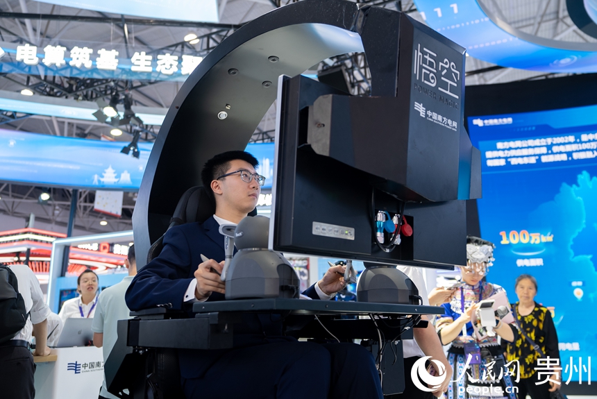 專業(yè)展現(xiàn)場,工作人員操作展示帶電作業(yè)機器人。人民網(wǎng)記者 涂敏攝